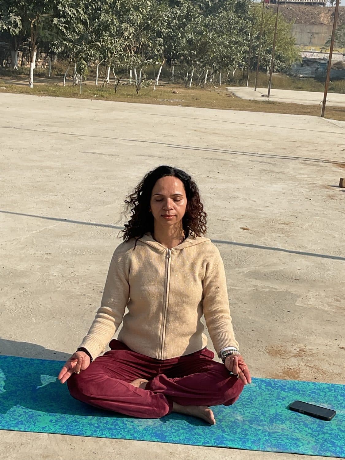 Sapna seated in meditation outdoors