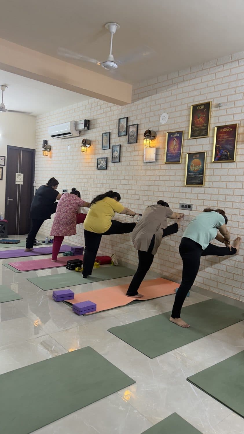 A class holding a standing balance pose on mats