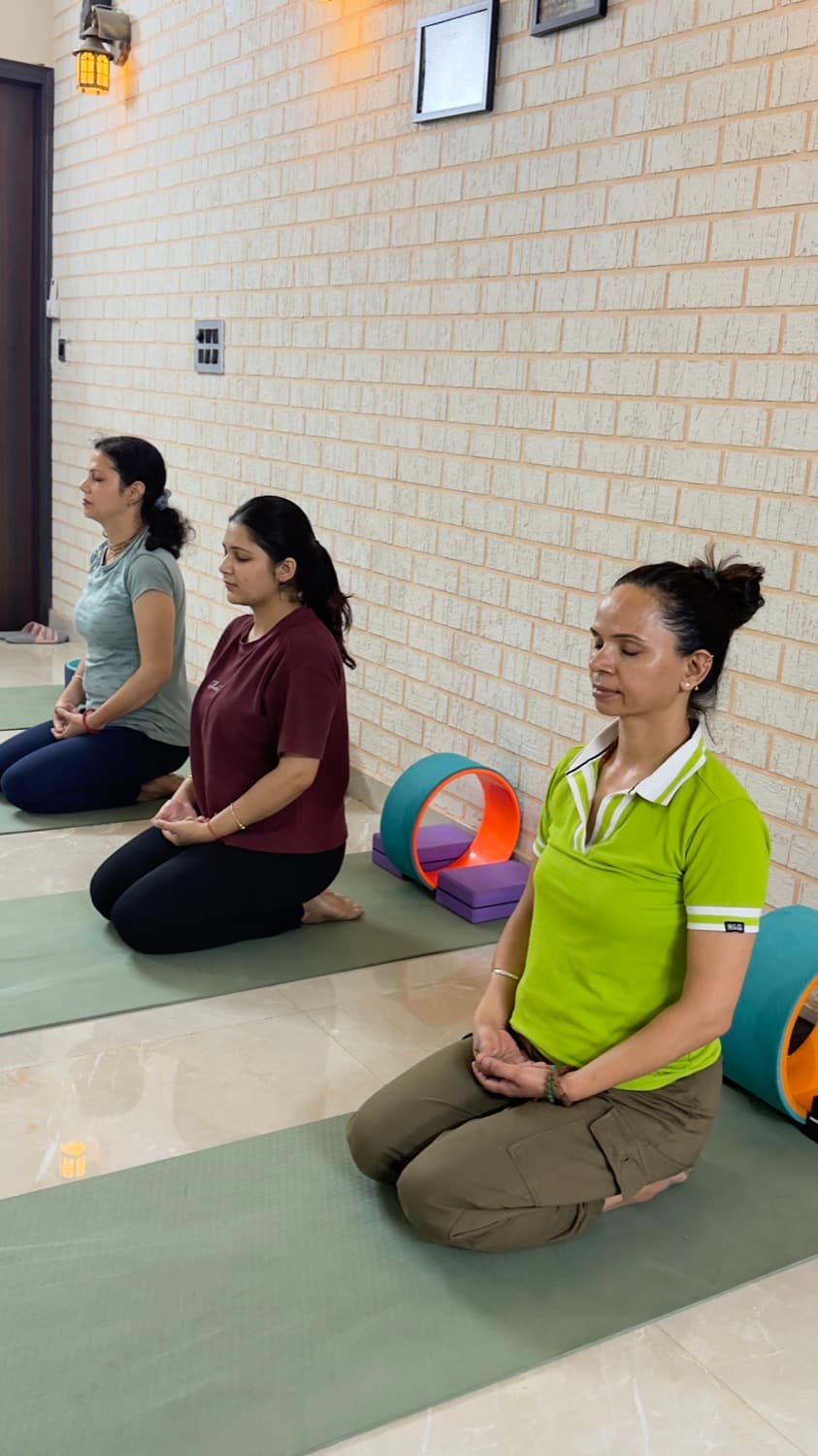 Students seated in meditation along the studio wall